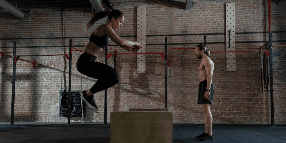 Woman doing box jumps in a crossfit gym.
